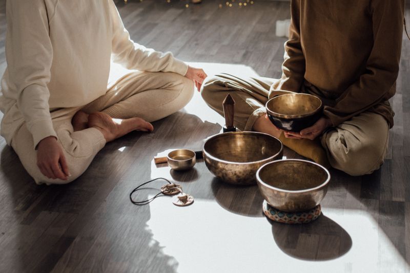 Two women in a quiet meditation session with singing bowls